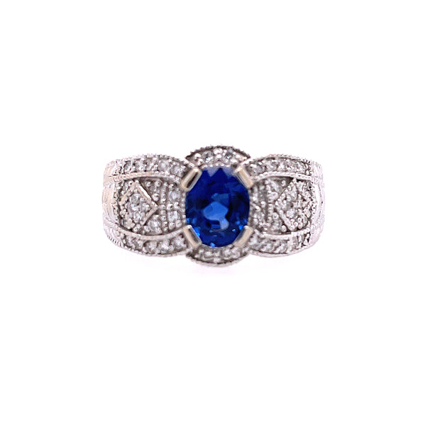 18K White Gold Ring Featuring Center Blue Sapphire At Approximately 1.25CT And 64 Round Diamonds Along Shank And Halo For A Total Weight Of .61CT